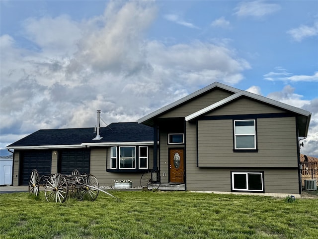 split level home with a garage, a front lawn, roof with shingles, and cooling unit