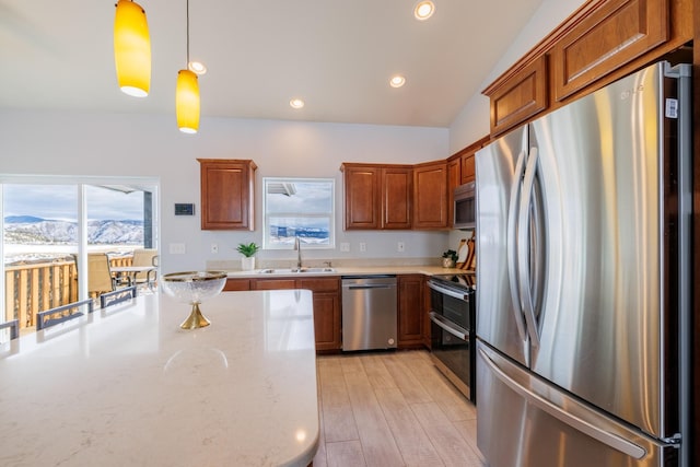 4645 Sea Ray Rd, Helena, MT 59602 - kitchen with stainless steel appliances, brown cabinets, hanging light fixtures, light stone countertops, and recessed lighting