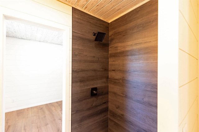details featuring a tile shower, wood finished floors, and wood ceiling