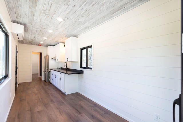kitchen featuring a wall mounted air conditioner, white cabinets, dark countertops, and high end refrigerator