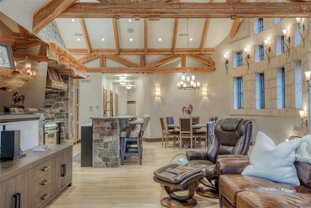 30 Bear Dance Vlg, Bigfork, MT 59911 - living room with high vaulted ceiling, light wood-style floors, beam ceiling, a chandelier, and a fireplace