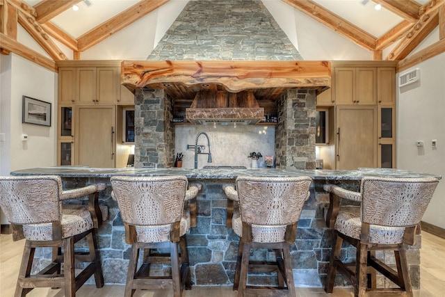 30 Bear Dance Vlg, Bigfork, MT 59911 - indoor wet bar with decorative backsplash, high vaulted ceiling, beam ceiling, light wood-style floors, and ventilation hood