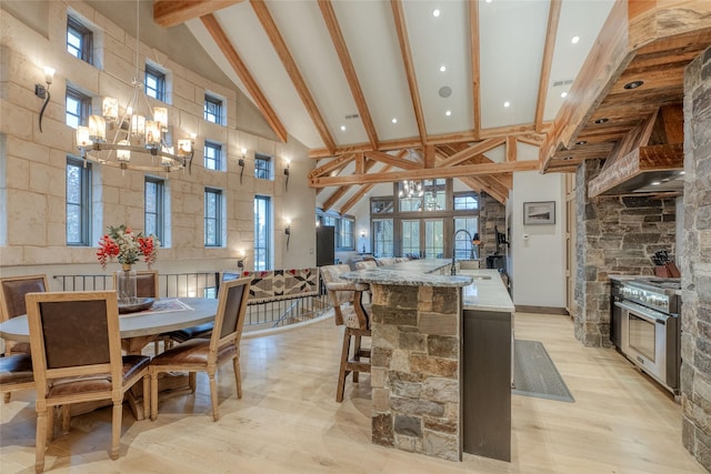 30 Bear Dance Vlg, Bigfork, MT 59911 - kitchen with high vaulted ceiling, beam ceiling, a kitchen island with sink, light wood-type flooring, and wall oven