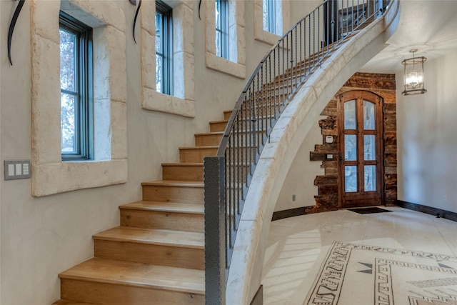 30 Bear Dance Vlg, Bigfork, MT 59911 - stairs featuring inlaid floor details, plenty of natural light, a high ceiling, and a chandelier