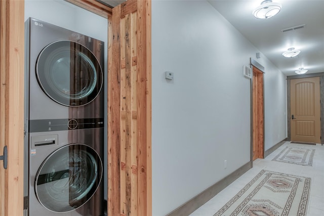 30 Bear Dance Vlg, Bigfork, MT 59911 - washroom with stacked washing machine and dryer and light tile patterned flooring