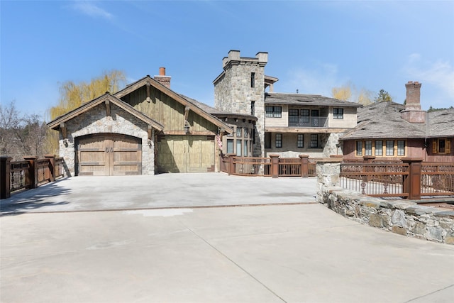 30 Bear Dance Vlg, Bigfork, MT 59911 - back of property featuring a chimney, stone siding, driveway, and a garage