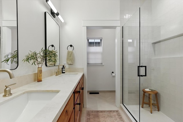 bathroom featuring a sink, a shower stall, and double vanity