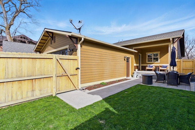 back of house with outdoor lounge area, a gate, fence, a yard, and a patio