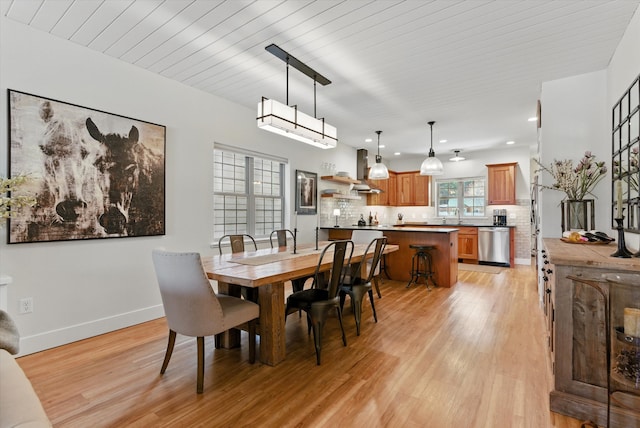 dining space with baseboards, recessed lighting, and light wood-type flooring