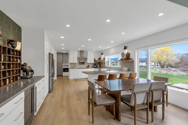 dining area featuring light wood-type flooring, wine cooler, and recessed lighting