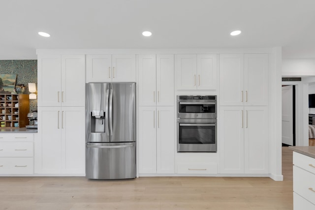 kitchen featuring white cabinets, appliances with stainless steel finishes, and recessed lighting