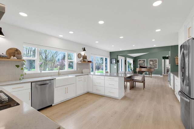 kitchen featuring appliances with stainless steel finishes, open shelves, and recessed lighting