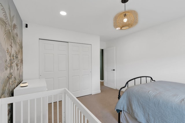 carpeted bedroom with baseboards, recessed lighting, and a closet