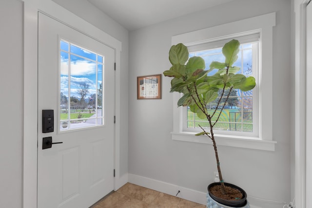 doorway to outside featuring baseboards and light tile patterned floors