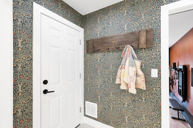 bathroom with wallpapered walls, wood finished floors, and visible vents