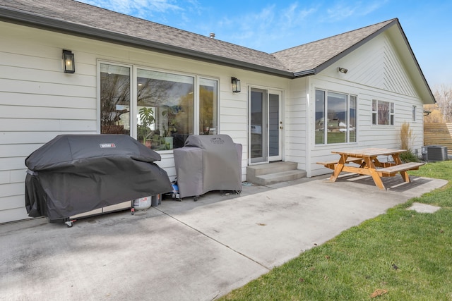 rear view of house featuring roof with shingles, a patio, cooling unit, and entry steps