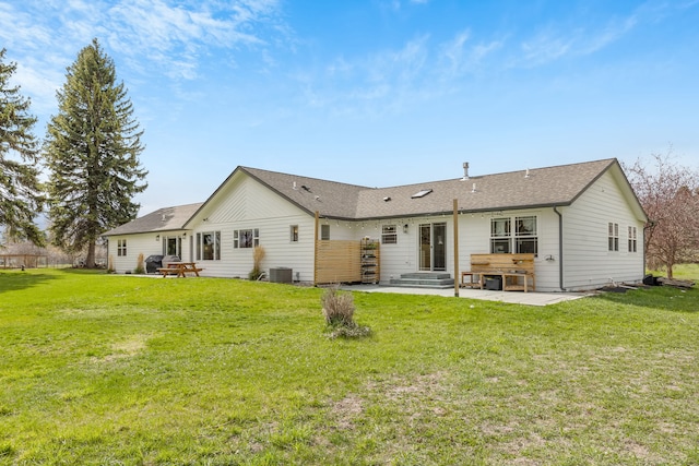 rear view of property featuring a patio area, a shingled roof, a yard, and central AC
