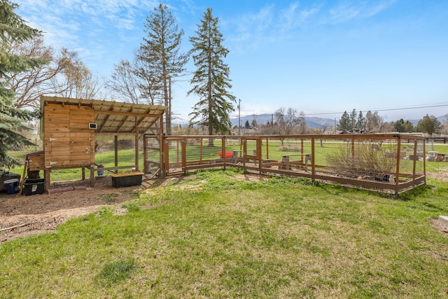 view of yard with a rural view, exterior structure, a vegetable garden, and a mountain view