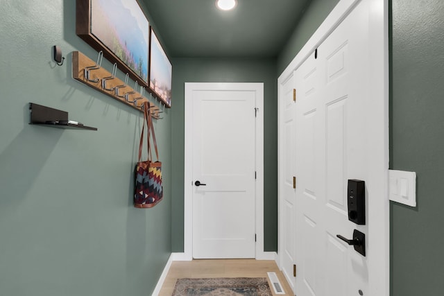 doorway featuring baseboards, visible vents, and light wood-type flooring