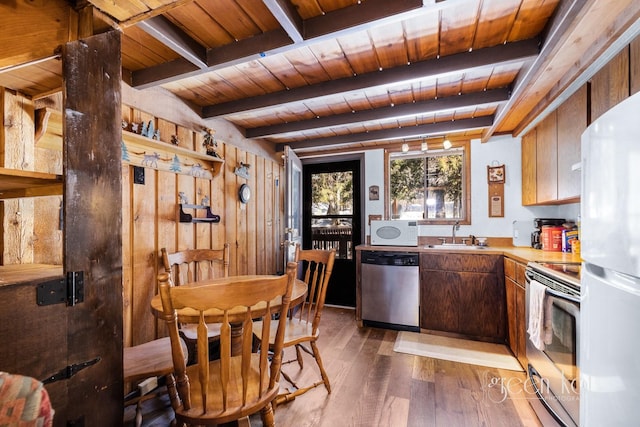 62 Limber Pne, Whitefish, MT 59937 - kitchen with white appliances, a wooden ceiling with exposed beams, dark wood finished floors, light countertops, and wood walls