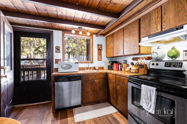 62 Limber Pne, Whitefish, MT 59937 - kitchen featuring stainless steel appliances, a wooden ceiling with exposed beams, under cabinet range hood, light countertops, and light wood-type flooring