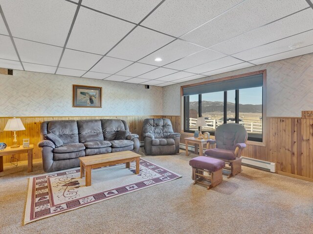3600 Fairmont Rd, Anaconda, MT 59711 - living area featuring a baseboard heating unit, a paneled ceiling, wood walls, and carpet