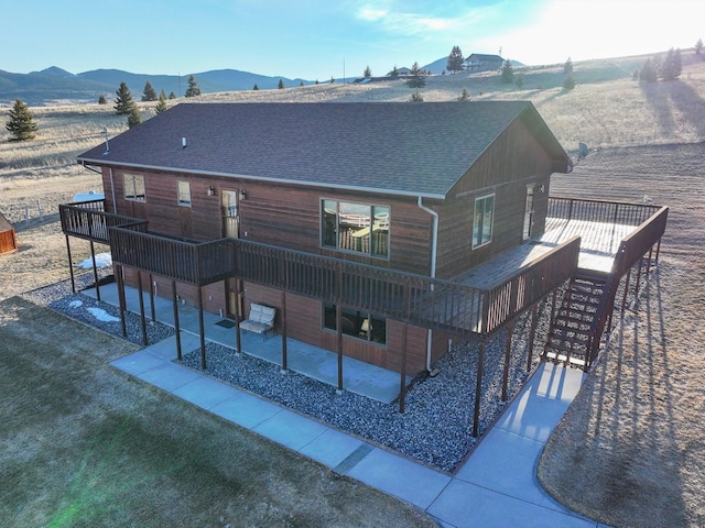 3600 Fairmont Rd, Anaconda, MT 59711 - rear view of house featuring stairway, a deck with mountain view, a patio, and a shingled roof