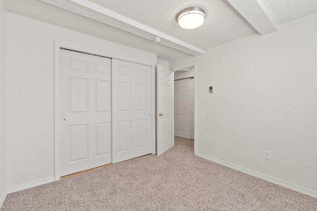 121 Iowa Ave Unit 1G, Whitefish, MT 59937 - unfurnished bedroom featuring carpet, a textured ceiling, and a closet