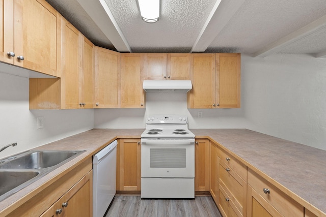 121 Iowa Ave Unit 1G, Whitefish, MT 59937 - kitchen with white appliances, under cabinet range hood, a textured ceiling, light wood finished floors, and light countertops