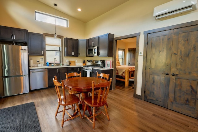 2360 Mt Highway 206, Columbia Falls, MT 59912 - kitchen with stainless steel appliances, a wall mounted AC, high vaulted ceiling, light countertops, and wood finished floors