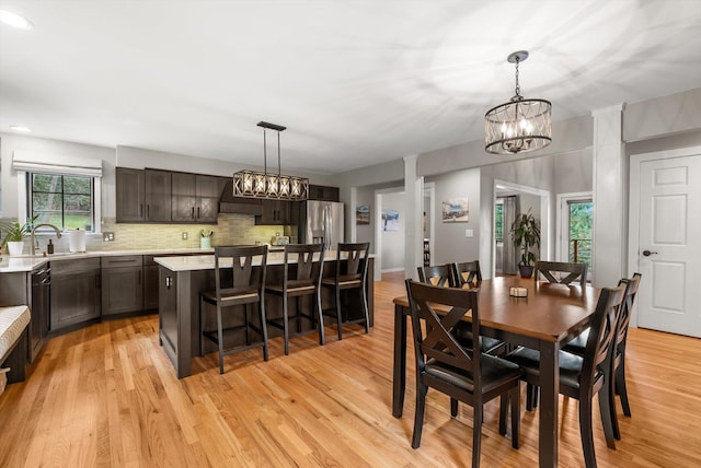 dining area featuring light wood-style flooring and an inviting chandelier