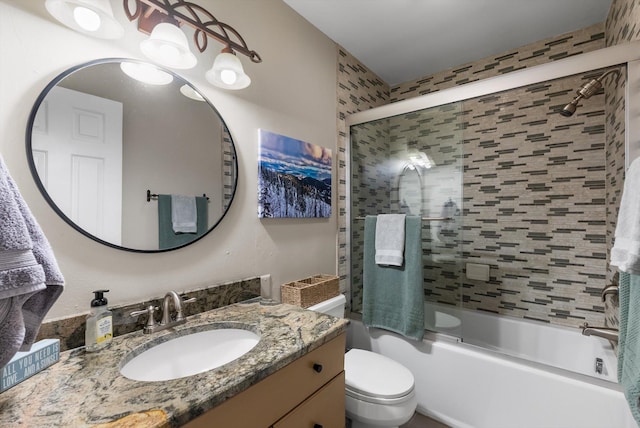 full bathroom with vanity, bath / shower combo with glass door, and toilet