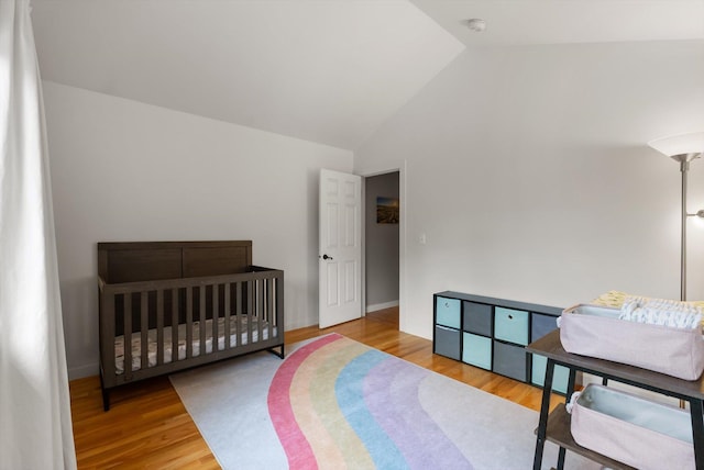 bedroom featuring wood finished floors and high vaulted ceiling