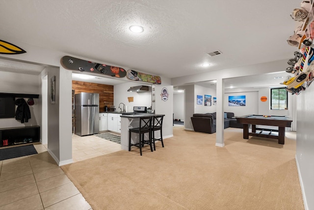 kitchen featuring dark countertops, a sink, open floor plan, pool table, and freestanding refrigerator