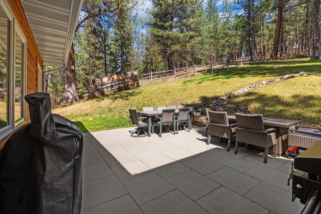 view of patio with outdoor dining area, grilling area, and a fenced backyard