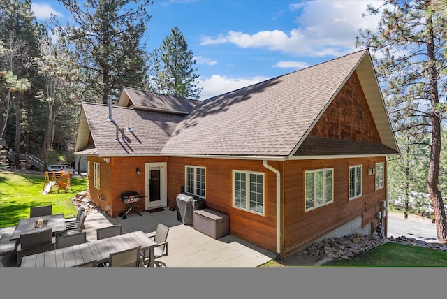 rear view of property with a lawn, a shingled roof, a patio, and an outdoor living space