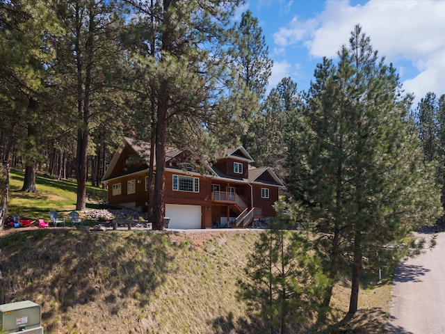 chalet / cabin featuring a garage and stairs