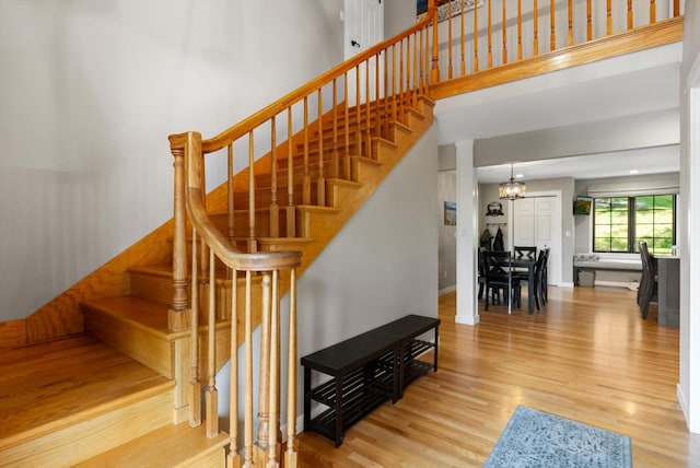 stairway featuring a towering ceiling and wood finished floors