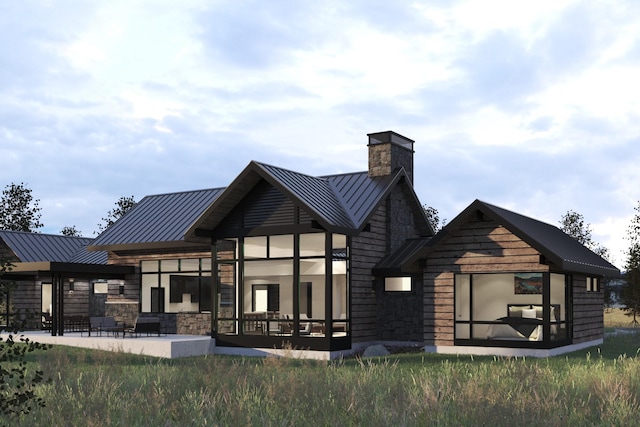 back of property with stone siding, a standing seam roof, and metal roof