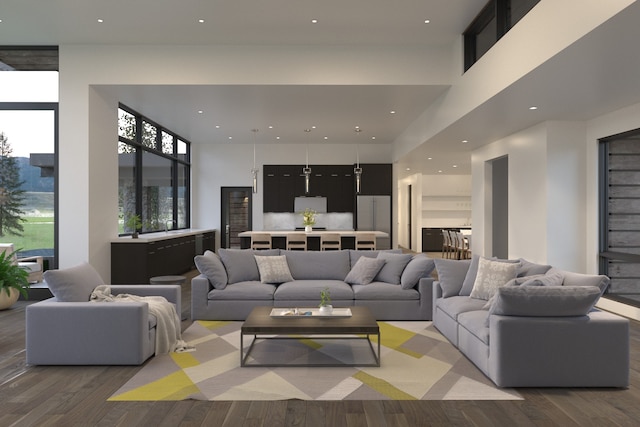 living area with a towering ceiling, wood finished floors, and recessed lighting