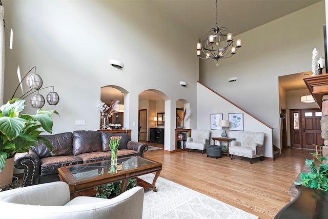 2200 Rafferty Ln, Missoula, MT 59804 - living area featuring arched walkways, a towering ceiling, light wood-type flooring, and a chandelier