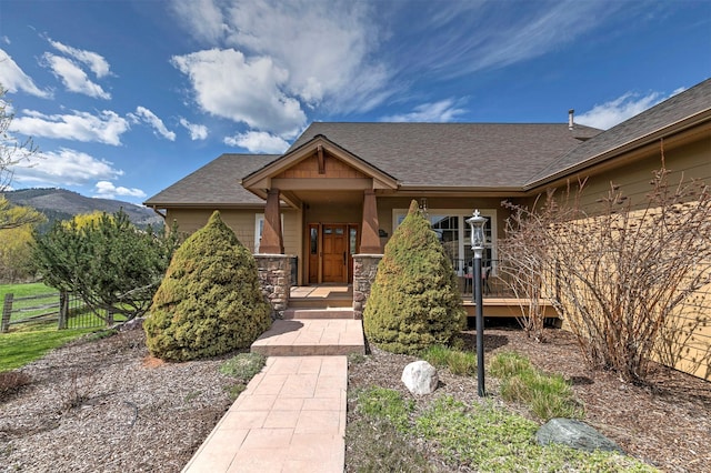 2200 Rafferty Ln, Missoula, MT 59804 - property entrance with a mountain view, a shingled roof, and stone siding