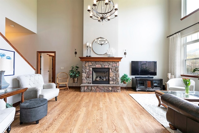 2200 Rafferty Ln, Missoula, MT 59804 - living room featuring a high ceiling, a chandelier, a stone fireplace, and wood finished floors