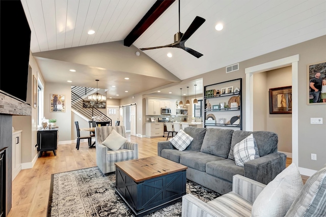 living room featuring ceiling fan with notable chandelier, lofted ceiling with beams, light wood-style floors, visible vents, and recessed lighting