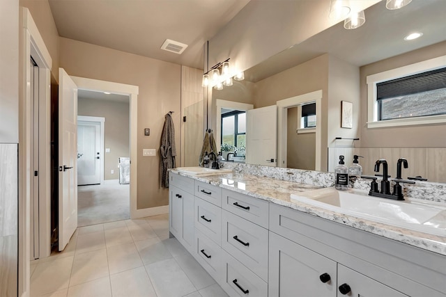 bathroom with tile patterned flooring, visible vents, a sink, and double vanity