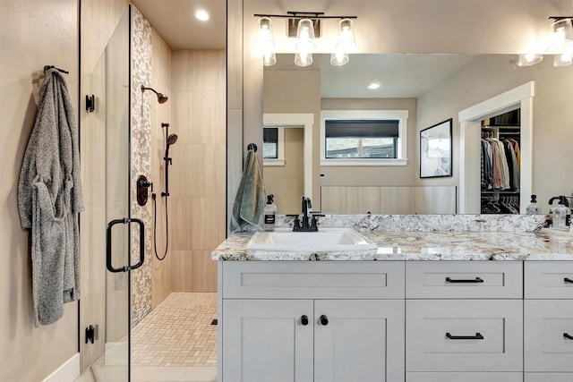 bathroom featuring vanity, a spacious closet, and a stall shower