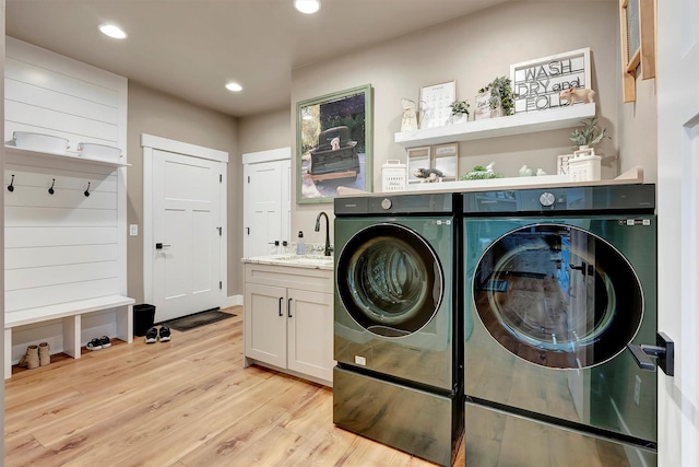 clothes washing area with recessed lighting, independent washer and dryer, light wood-type flooring, and a sink