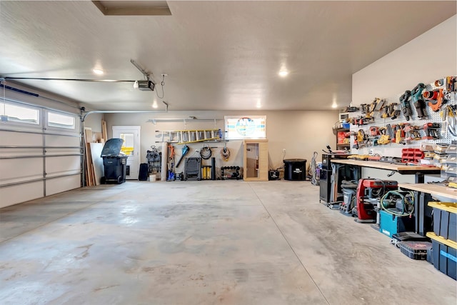 garage with a workshop area and a garage door opener