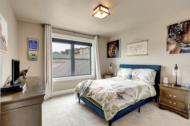 bedroom with baseboards and light colored carpet