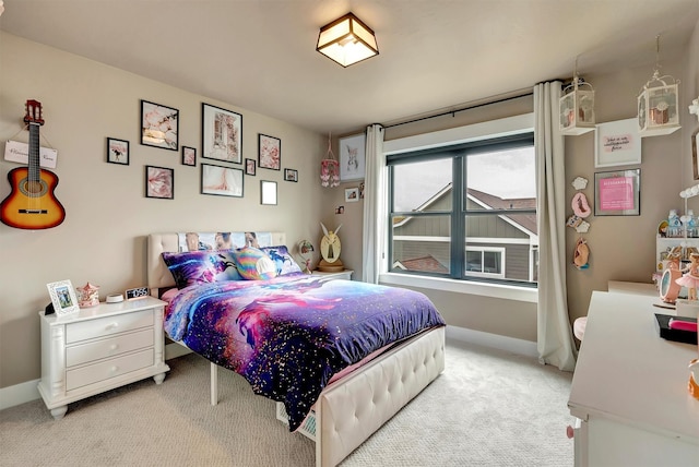 bedroom featuring light carpet and baseboards
